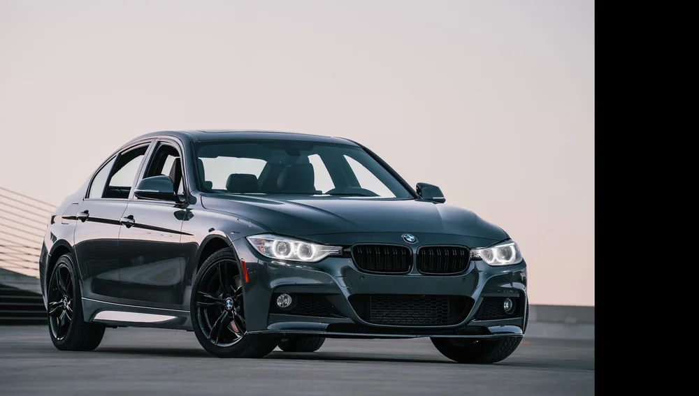 Sedan hitam terparkir saat matahari terbenam, ilustrasi servis BMW Series 3